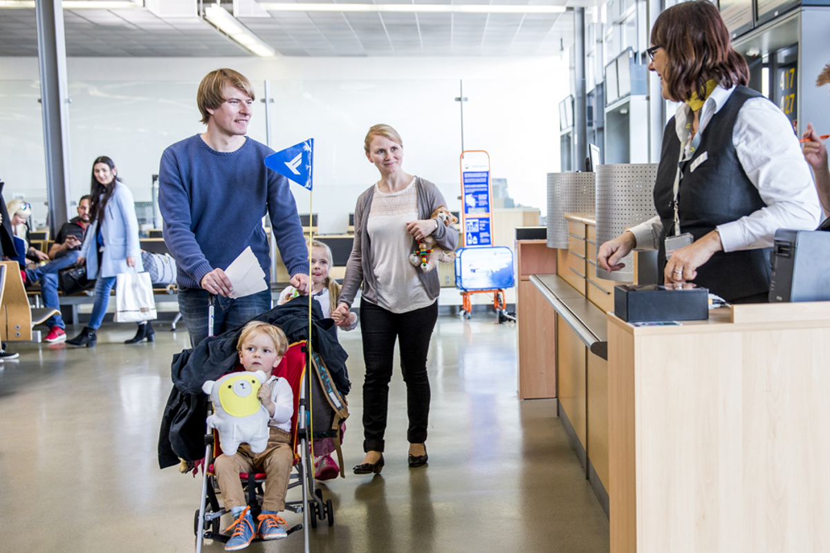 Familie mit Kind am Gate beim Boarding