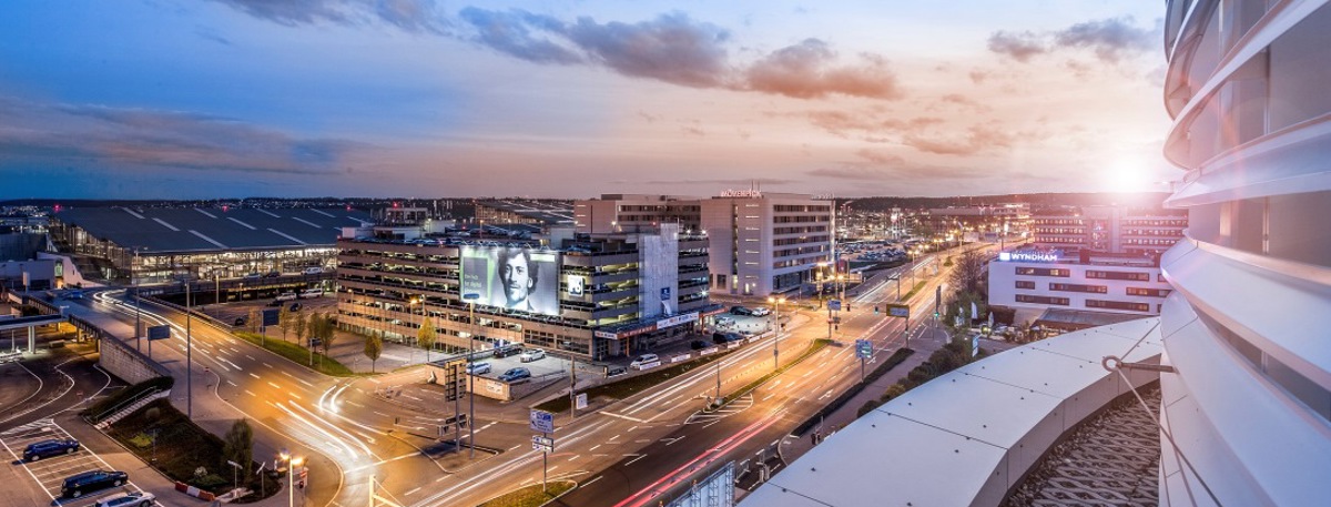 Blick auf die beleuchtete AirportCity mit untergehender Sonne im Westen